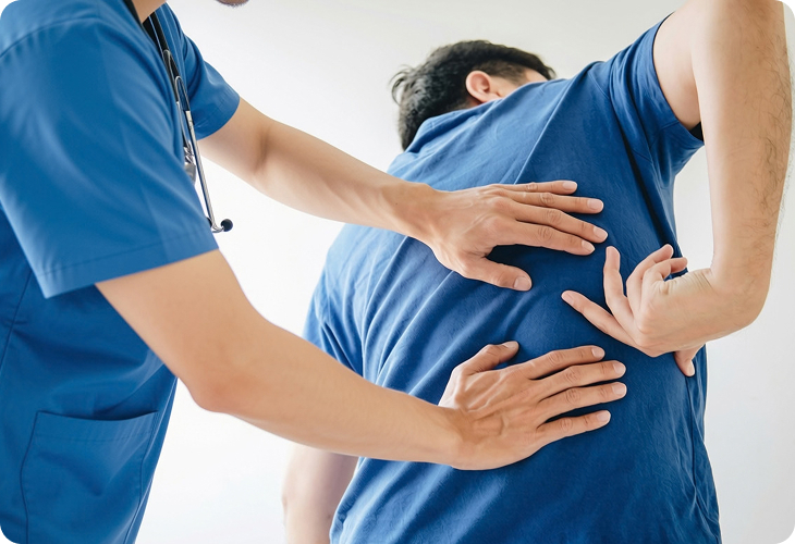 Clinician assessing a patient with back pain